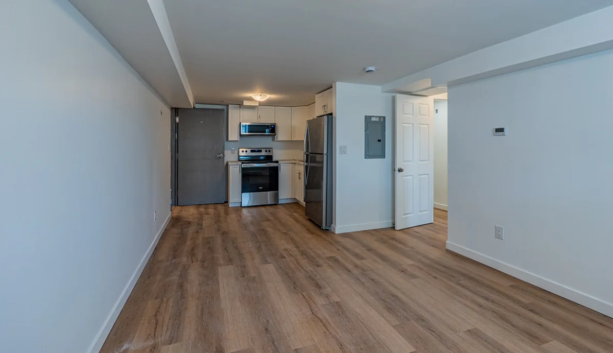 Open living space at handover, plank floor running to the far wall