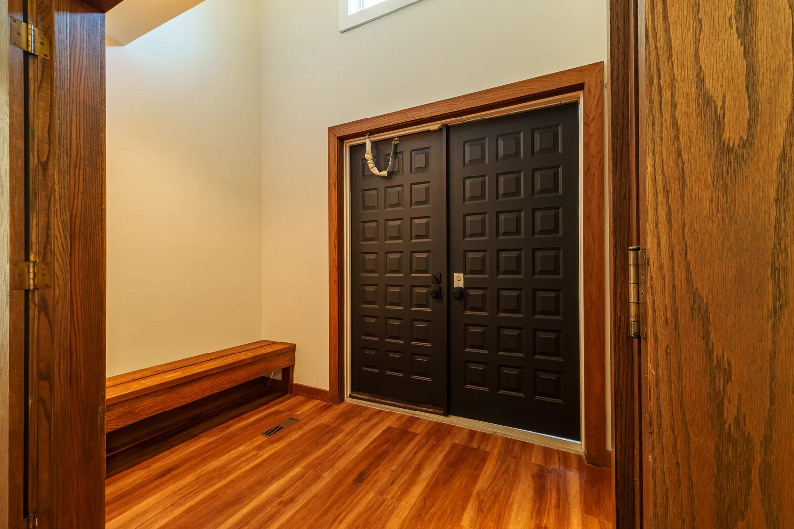 Panelled front door and bench in the refinished entry