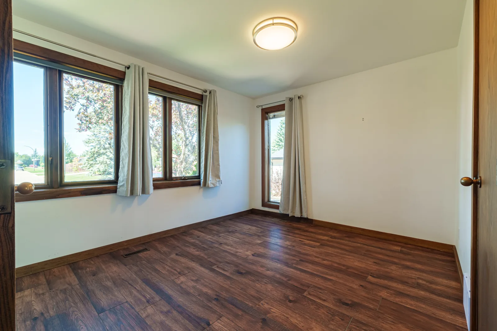 Empty living room at handover, windows onto the garden