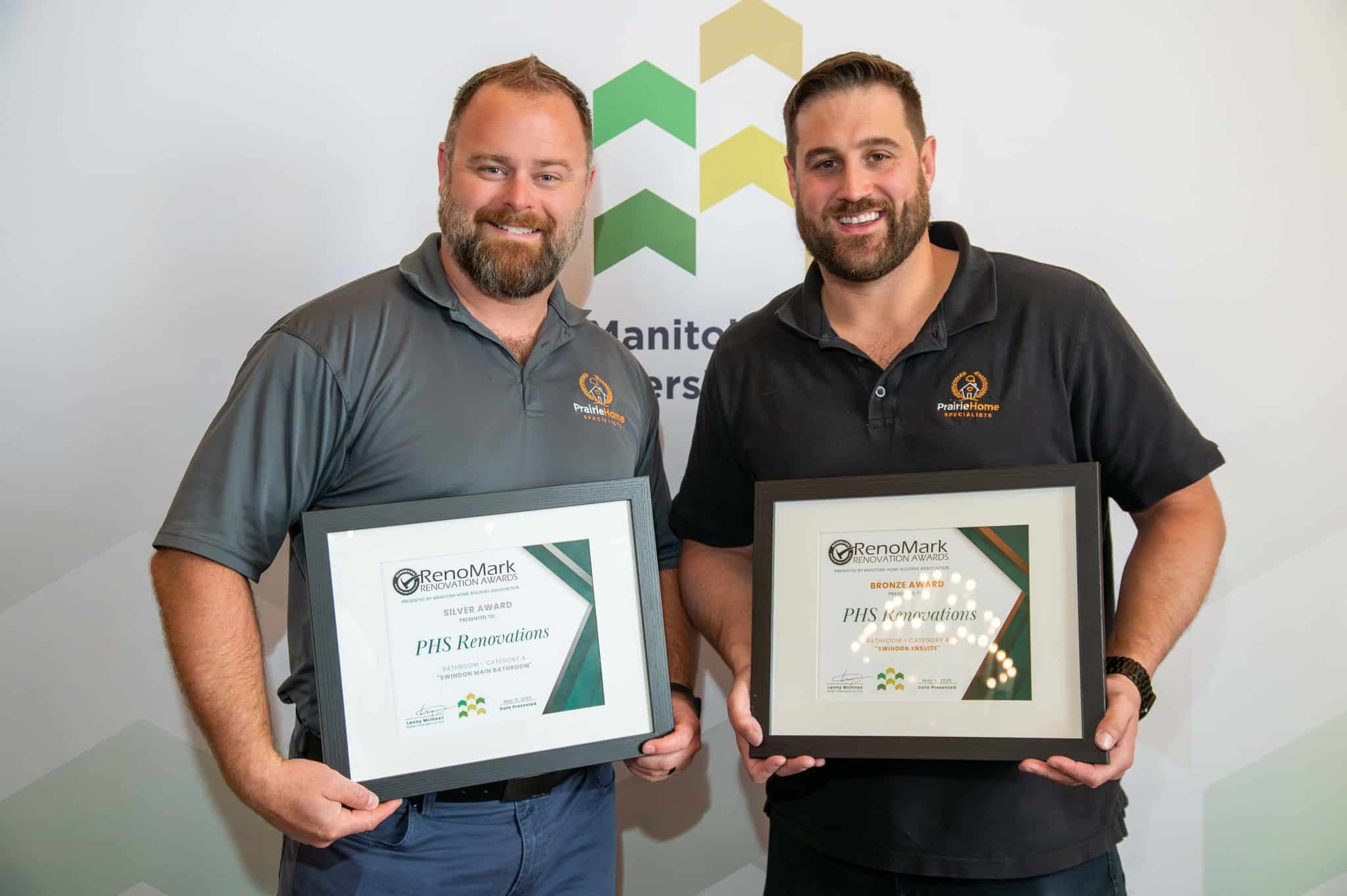 Mark and Chase holding PHS Renovations' RenoMark Renovation Awards — Silver and Bronze